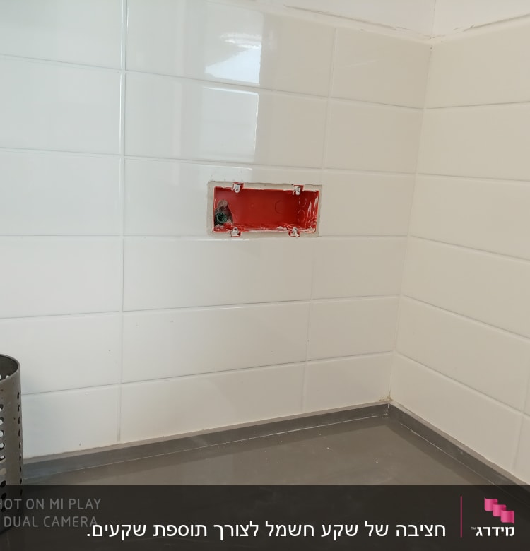 תיבת חשמל פתוחה בקיר אריחים לבנים